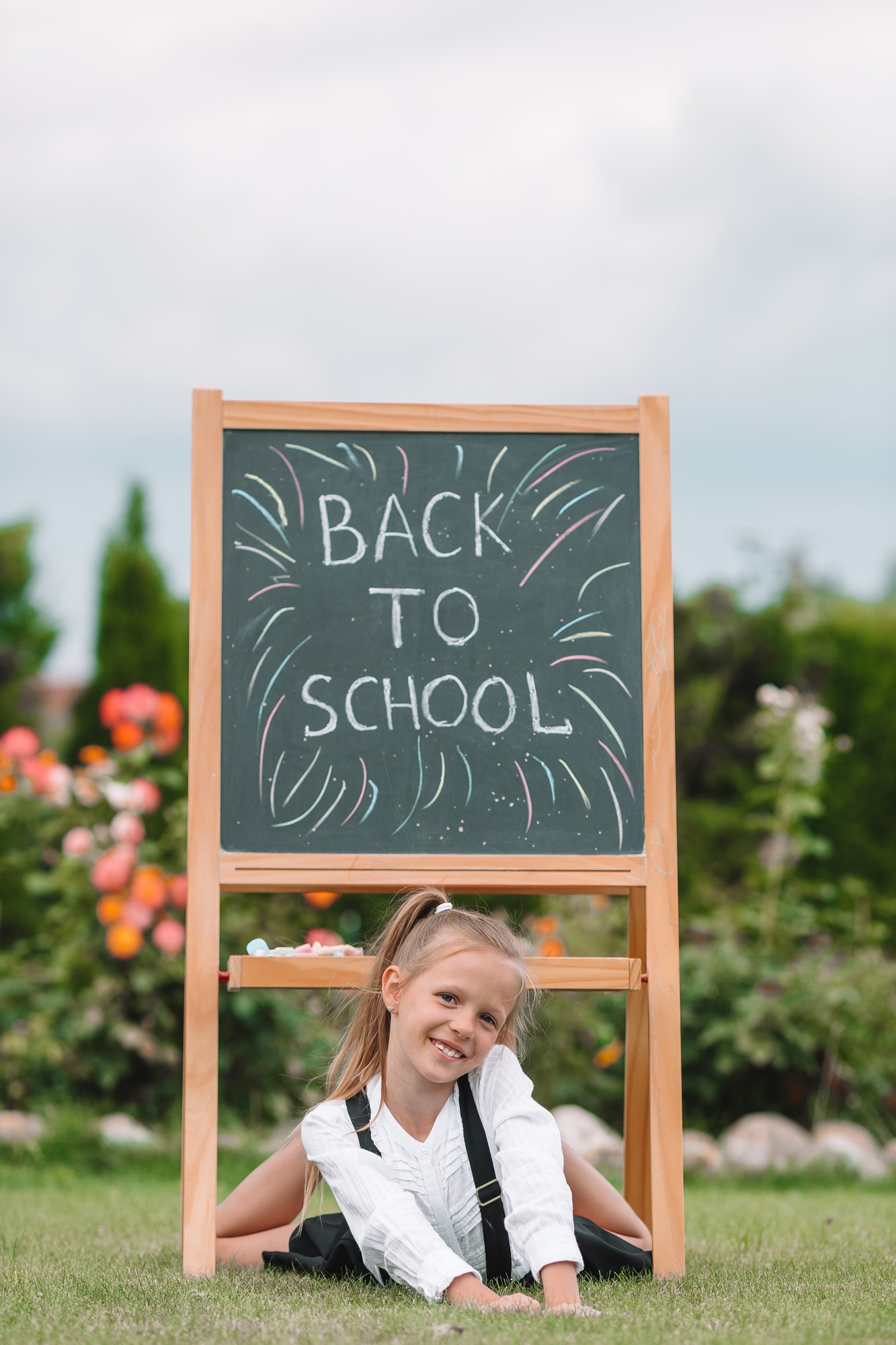 Happy little schoolgirl with a chalkboard outdoor