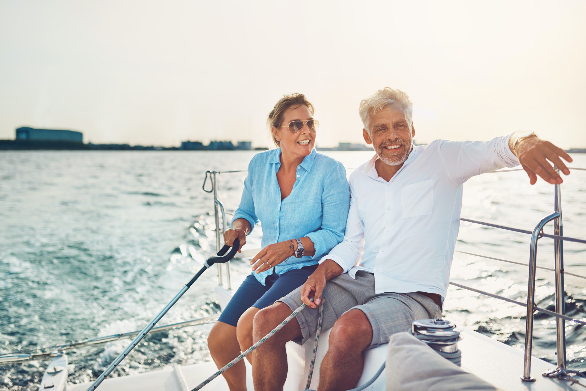 Smiling mature couple sailing their boat on a sunny afternoon