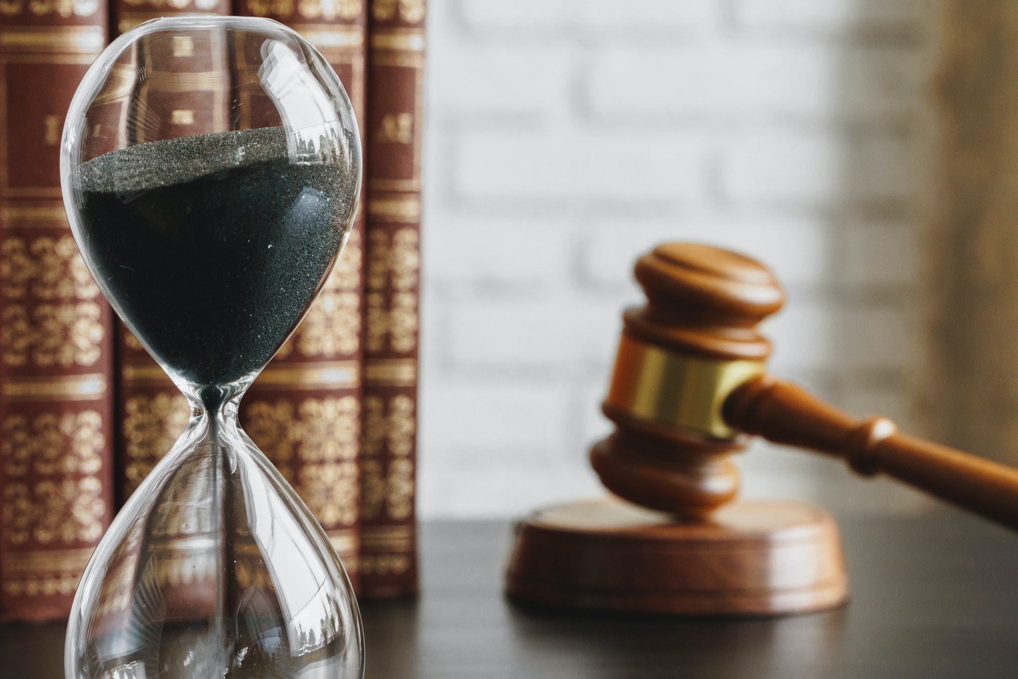 Hourglass and gavel on table