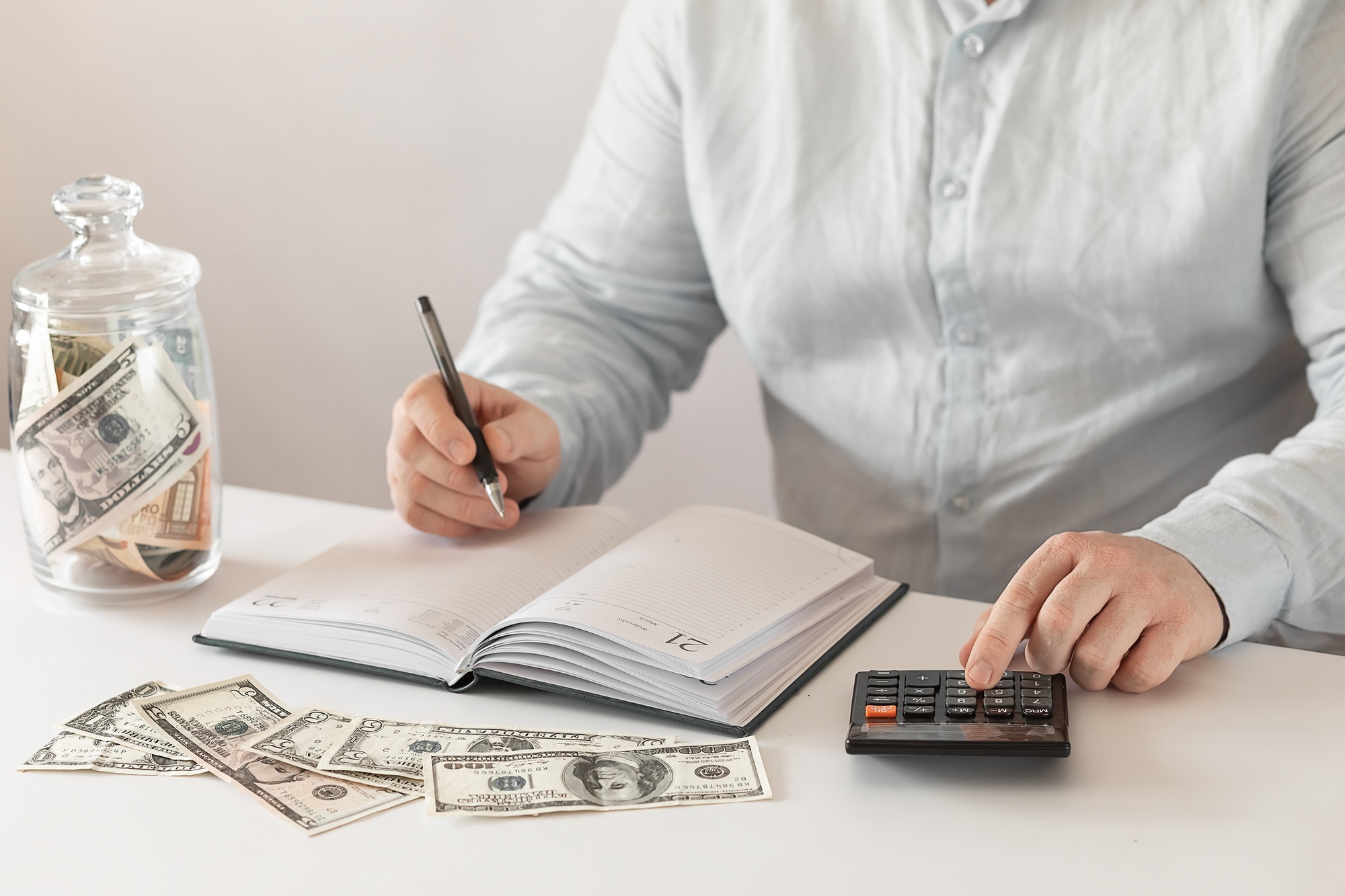 Man calculating income on calculator Man calculating income on calculator